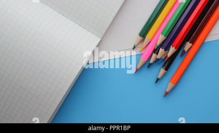 Direttamente sopra il colpo di matite colorate da libri su sfondo blu Foto Stock