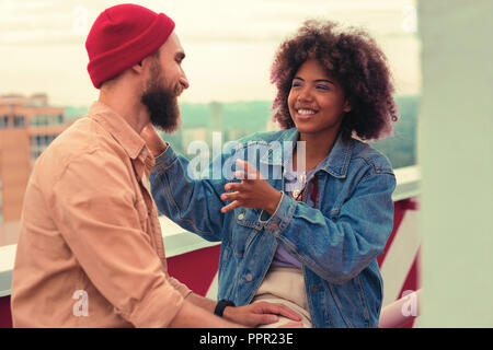 Positivo giovane ragazza sorridente e avente interessante parlare con il suo amato uomo Foto Stock