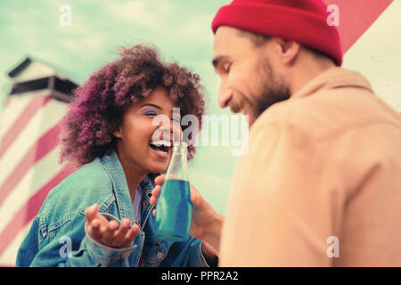 Coppia emotiva di ridere e di bere gustosi limonata blu Foto Stock