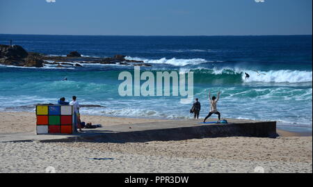 Sydney, Australia - 5 luglio 2015. Rubik Cube si trova sulle rive di Maroubra Beach. Persone per godere del sole e prendere l'esercizio. Foto Stock