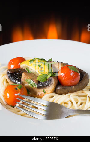 Piatto vegetariano di funghi saltati e pomodorini con spaghetti Foto Stock