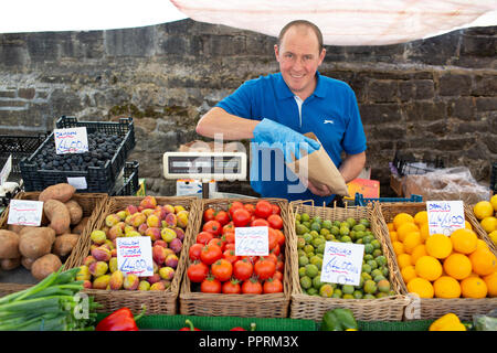 La frutta e la verdura titolare di stallo su un mercato in Yorkshire . Questo tipo di rivenditore utilizza una minore quantità di imballaggi in plastica su frutta e verdura Foto Stock
