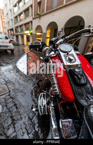 Harley Davidson Moto parcheggiata sotto la pioggia al di fuori Il Santo Bevitore, uno sport bar in Via Gallerie, Bologna, Italia. Foto Stock