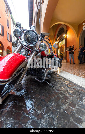 Harley Davidson Moto parcheggiata sotto la pioggia al di fuori Il Santo Bevitore, uno sport bar in Via Gallerie, Bologna, Italia. Foto Stock