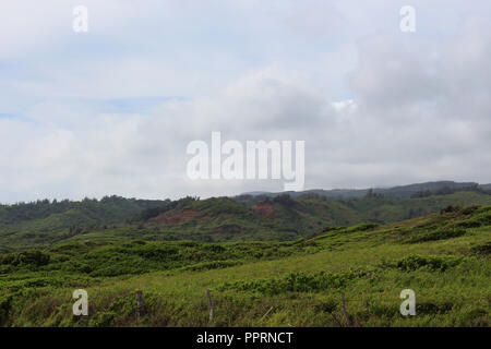 Il rotolamento verde e lussureggiante vegetazione riempito pendii lungo l'autostrada 30 sul lato nord-est di Maui, Hawaii, STATI UNITI D'AMERICA Foto Stock