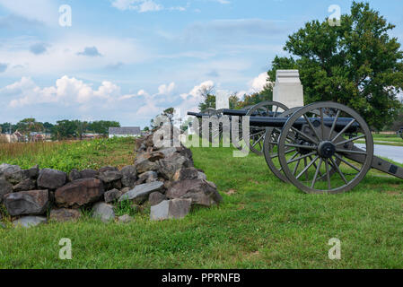 Cannoni da guerra civile sono allineati dietro a un muro di pietra nel Parco Militare Nazionale di Gettysburg. Foto Stock