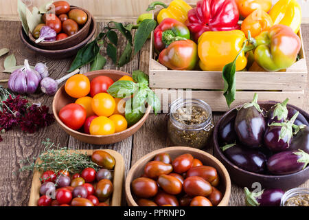 Verdure colorate su rurale tavolo in legno, fresche agricoltore biologico peperoni, melanzane e pomodori, raccolto autunnale ancora tempo di vita Foto Stock