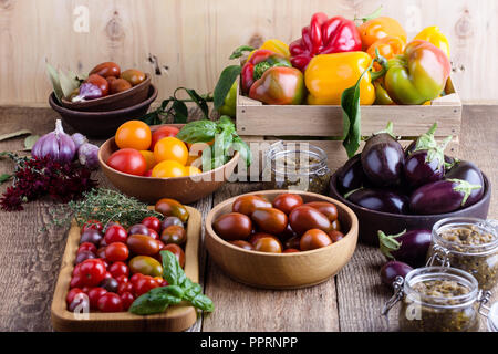 Verdure colorate su rurale tavolo in legno, fresche agricoltore biologico peperoni, melanzane e pomodori, raccolto autunnale ancora tempo di vita Foto Stock