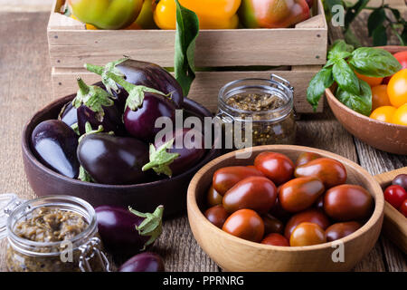 Verdure colorate su rurale tavolo in legno, fresche agricoltore biologico peperoni, melanzane e pomodori, raccolto autunnale ancora tempo di vita Foto Stock