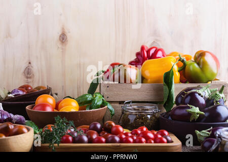 Verdure colorate su rurale tavolo in legno, fresche agricoltore biologico peperoni, melanzane e pomodori, raccolto autunnale ancora tempo di vita Foto Stock