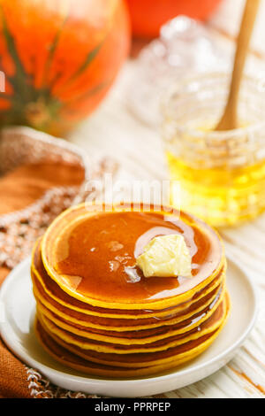 Freschi Fatti in casa frittella di zucca con il miele e il burro in una piastra bianca. Tradizionale gustoso sana colazione per buongustai. Messa a fuoco selettiva Foto Stock