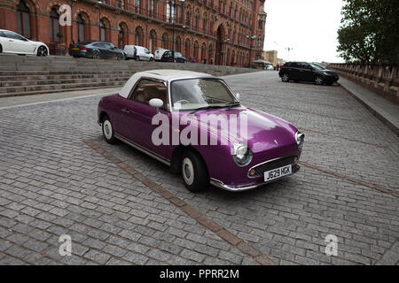 Nissan Figaro parcheggiato su acciottolato presso la stazione di St. Pancras, London. Foto Stock