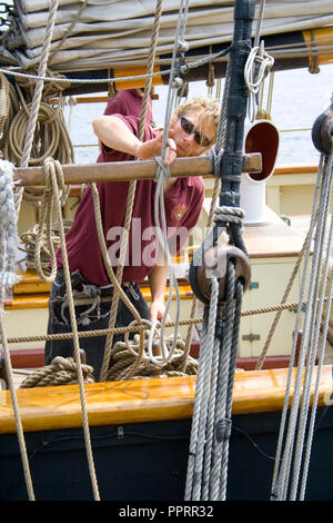 Membro di equipaggio opere sulla fune di ancoraggio sul Tall Ship Pride of Baltimore II ormeggiata nel porto di Duluth del Lago Superior Duluth Minnesota MN USA Foto Stock