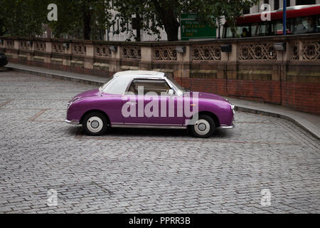 Nissan Figaro parcheggiato su acciottolato presso la stazione di St. Pancras, London. Foto Stock