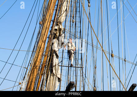 Sailor ispezionando il rigging su tall ship Pride of Baltimore II ormeggiata nel porto di Duluth per il Festival marittimo. Duluth Minnesota MN USA Foto Stock