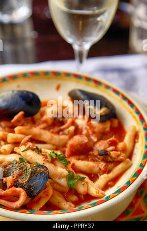 Primo piano di cozze, Calamari e altri frutti di mare in salsa rossa su piatto di pasta in un ristorante a Vrbnik, sull'isola croata di Krk, sull'Adriatico Foto Stock