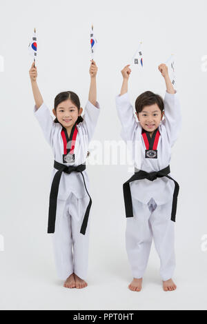 Bambini all'istruzione. Taekwondo, piccolo ragazzo e ragazza pratica le arti marziali in sfondo bianco 248 Foto Stock