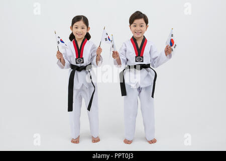 Bambini all'istruzione. Taekwondo, piccolo ragazzo e ragazza pratica le arti marziali in sfondo bianco 246 Foto Stock