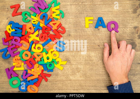 Disporre a mano le lettere di plastica come abbreviazione di FAQ ( domande frequenti ) Foto Stock