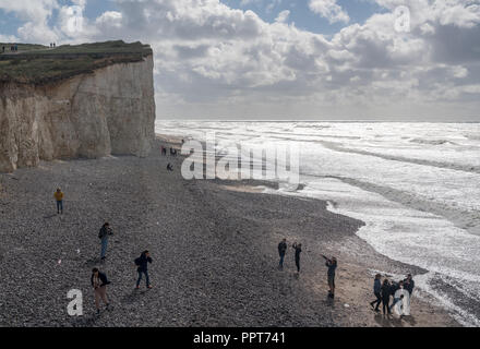 I turisti sulla spiaggia rocciosa a Birling Gap, Sussex Foto Stock