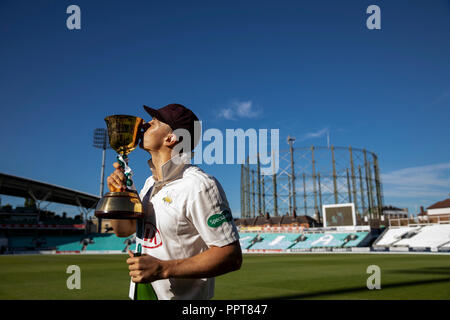 Surrey è Tom Curran festeggia con la Contea Campionato trofeo durante il giorno quattro del Specsavers County Championship Division una corrispondenza alla Kia ovale, Londra. Foto Stock