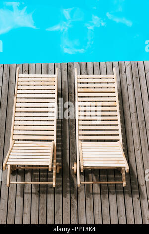 Angolo di alta vista del vuoto chaise longue vicino alla piscina Foto Stock