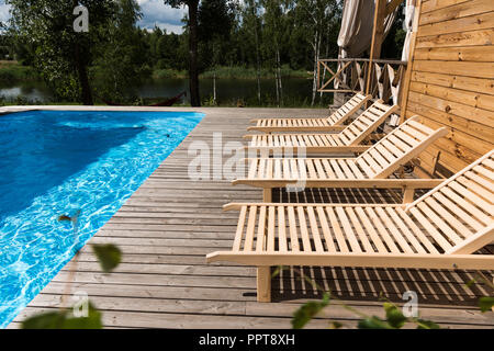 Vuoto accogliente chaise lounge vicino alla piscina Foto Stock