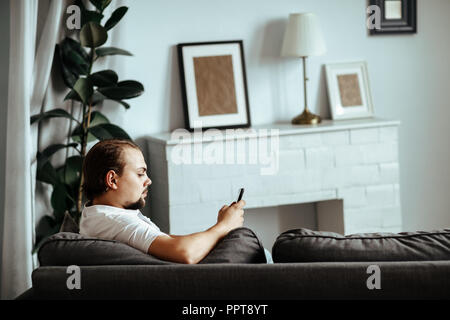 Uomo bello è seduto sul divano di casa Foto Stock