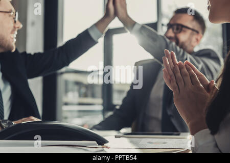 Business di successo di persone dando alta cinque durante la riunione in ufficio moderno Foto Stock