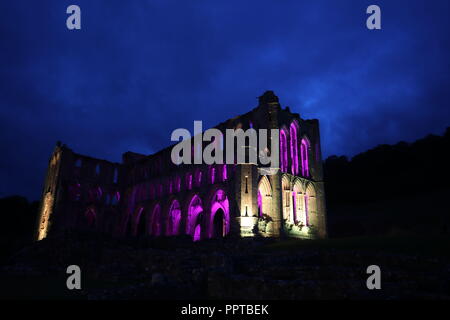 Rievaulx Abbey inondate di luce colorata in anticipo di Rievaulx illuminante, a tre notte luce e suono installazione presso l abbazia del XI secolo rovine nel North Yorkshire. Foto Stock