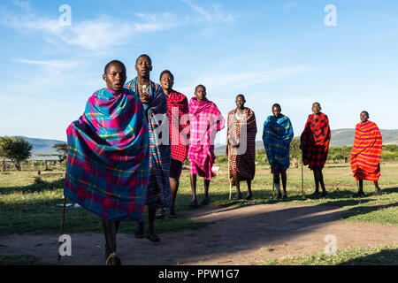 Maasai gente che esegue una danza di benvenuto per i turisti, Maasai Mara, Kenya Foto Stock