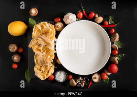 Fettuccine tagliatelle pasta e piastra bianca con funghi, erbe e spezie Foto Stock