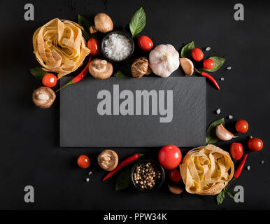 Fettuccine tagliatelle pasta e scheda di ardesia con funghi, erbe e spezie Foto Stock