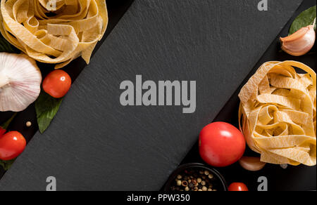 Fettuccine tagliatelle pasta e scheda di ardesia con funghi, erbe e spezie Foto Stock