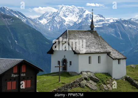 Nei pressi del villaggio di Bettmeralp nel cantone del Vallese (Svizzera) una piccola chiesa bianca è in piedi in campi verdi Foto Stock