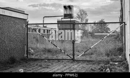 In un abbandono del sito industriale di un grande cancello di ferro è bloccato verso una fabbrica chiusa. Si trova nella città di Almelo nella provincia di Overijssel Foto Stock