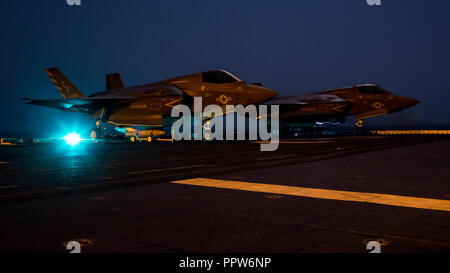 Stati Uniti Quinta Flotta AREA DI OPERAZIONI - STATI UNITI Marines con Marine Fighter Squadron di attacco 211, 13 Marine Expeditionary Unit (MEU), stadio ordnance prima di caricarla in un F-35B Lightning II a bordo del Wasp-classe assalto anfibio nave USS Essex (LHD 2) in preparazione per la F-35B del primo sciopero di combattimento, Sett. 27, 2018. L'Essex è il fiore all' occhiello per la Essex anfibio gruppo pronto e, con l'avviato XIII MEU, è distribuito negli Stati Uniti Quinta Flotta area di operazioni a sostegno di operazioni navali per garantire stabilità marittimo e la sicurezza nella regione centrale di collegamento del Mediterraneo e th Foto Stock