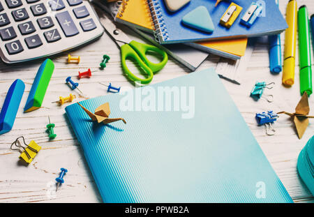 Si torna a scuola. Un notebook blu è sdraiato su un tavolo bianco. Foto Stock