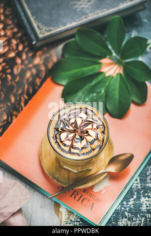 Latte caffè con salsa di cioccolato pattern in bicchiere alto Foto Stock