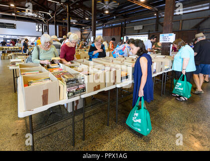 Ai clienti di navigare attraverso le scatole a Vinnies Book Fair, Cairns, estremo Nord Queensland, FNQ, QLD, Australia Foto Stock