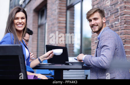 Azienda giovane in occasione di una riunione in una street cafe Foto Stock