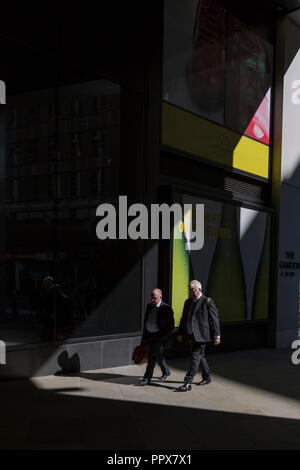 Persona d'affari a piedi attraverso la luce del sole nella città di Londra, capitale finanziaria del cuore (aka Square Mile), il 26 settembre 2018, a Londra, in Inghilterra. Foto Stock