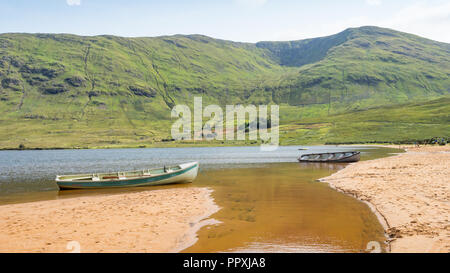 Barche sulla spiaggia presso il pittoresco lago Nafooey nella Contea di Galway in Irlanda. Foto Stock