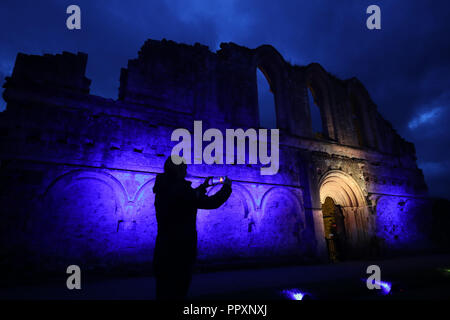 Rievaulx Abbey inondate di luce colorata in anticipo di Rievaulx illuminante, a tre notte luce e suono installazione presso l abbazia del XI secolo rovine nel North Yorkshire. Foto Stock