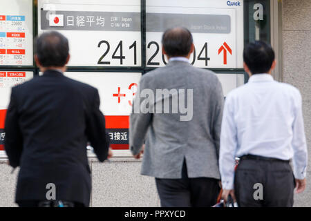 Tokyo, Giappone. Il 28 settembre 2018. I pedoni a piedi passato un magazzino elettronico di bordo che mostra in Giappone il Nikkei stock medio su Settembre 28, 2018, Tokyo, Giappone, il Nikkei Stock finito medio a 24,120.04, fino 323.30 o 1,36 percento, il suo più alto vicino a quasi 25 anni dal gennaio 1991. Credito: Rodrigo Reyes Marin/AFLO/Alamy Live News Foto Stock