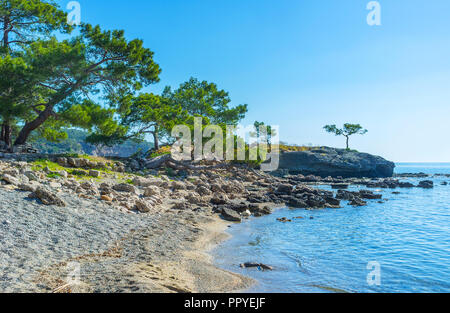 Passeggiata lungo la riva di ghiaia della battaglia Porto di Phaselis, Tekirova, Turchia. Foto Stock