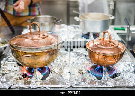 Due di bronzo, vintage pentole su fornelli a gas nel ristorante di cucina Foto Stock