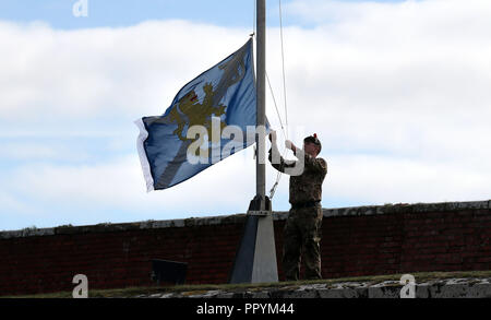 Un soldato alza la bandiera del reggimento dopo che il Principe di Galles, noto come il Duca di Rothesay mentre in Scozia, presentato campagna in Iraq medaglie ai soldati del Black Watch, 3° battaglione del reggimento reale di Scozia (3 Scots) truppe a Fort George, Inverness. Foto Stock