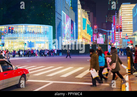 La gente che camminava sul bivio al carrello Shanghai street illuminata di sera, Cina Foto Stock