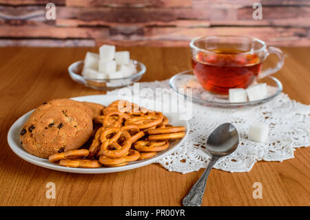 Ricco il tè in un bicchiere di vetro. i cookie e lo zucchero raffinato Foto Stock